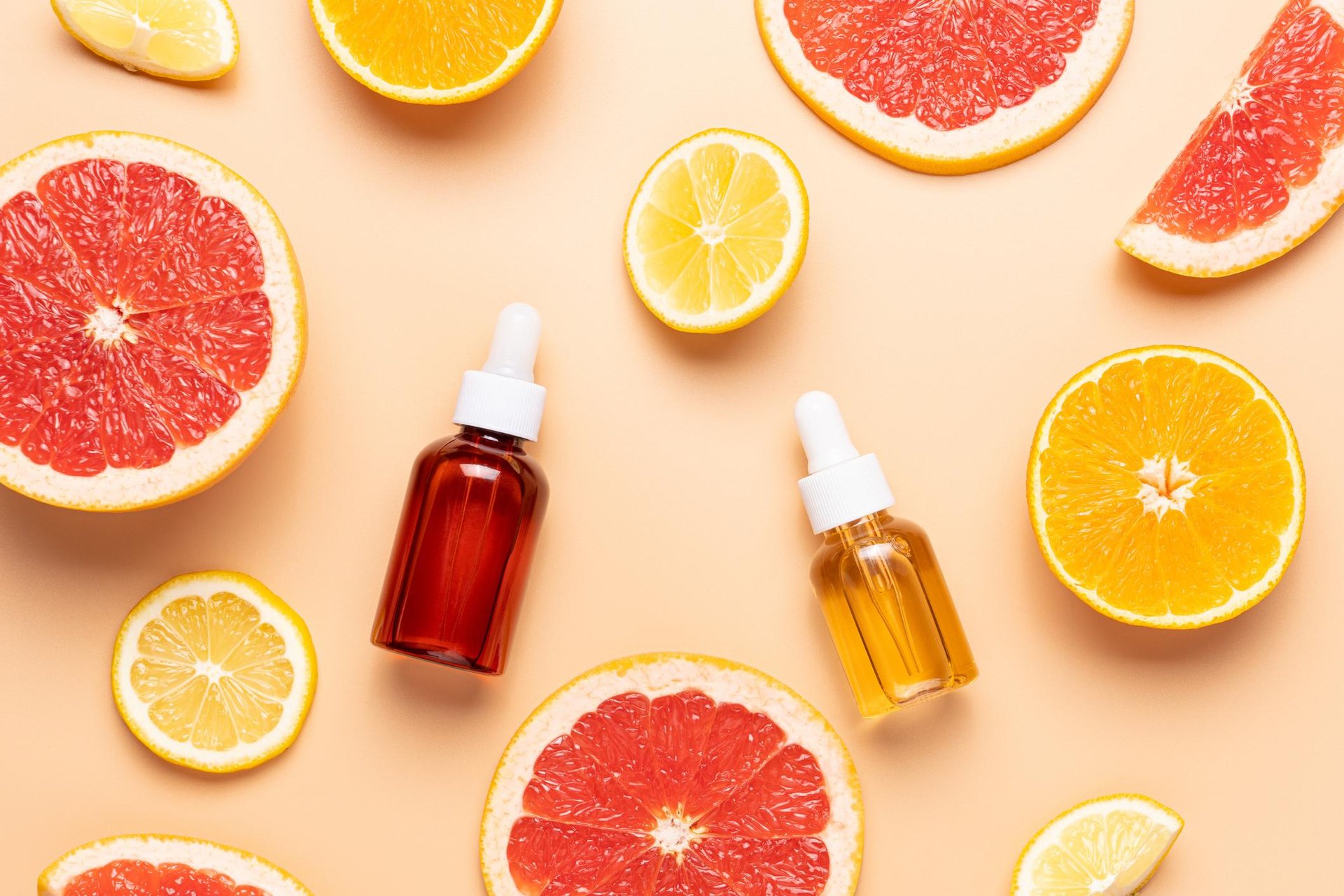 Vitamin C Seren auf gelbem Hintergrund mit Orangenscheiben