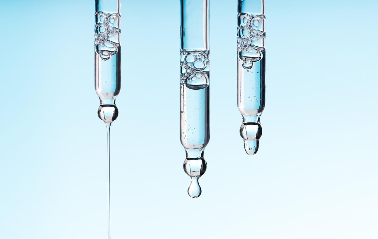 Pipetten mit Serum auf blauem Hintergrund