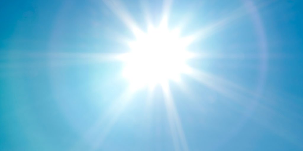 Die Sonne strahlt am blauen Himmel