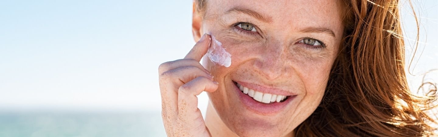 Frau mit Sommersprossen im Gesicht am Strand