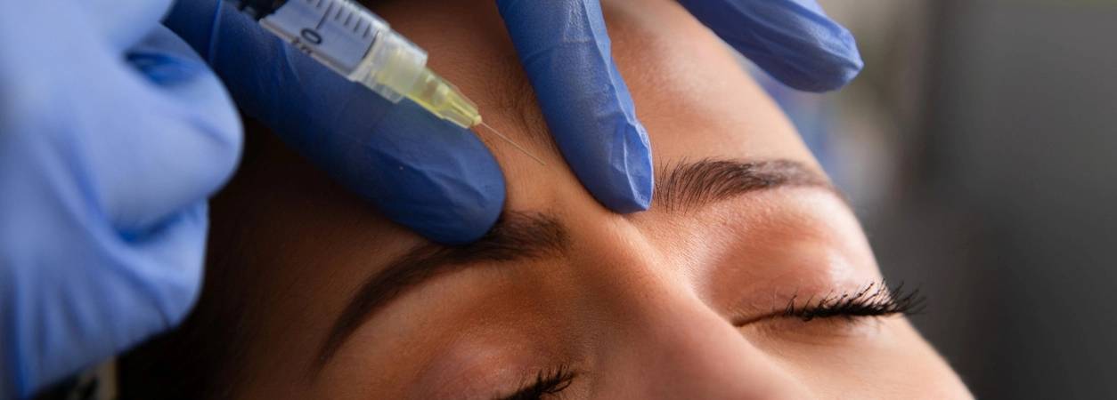 Injection d'acide hyaluronique : Une femme se fait injecter de l'acide hyaluronique dans le front