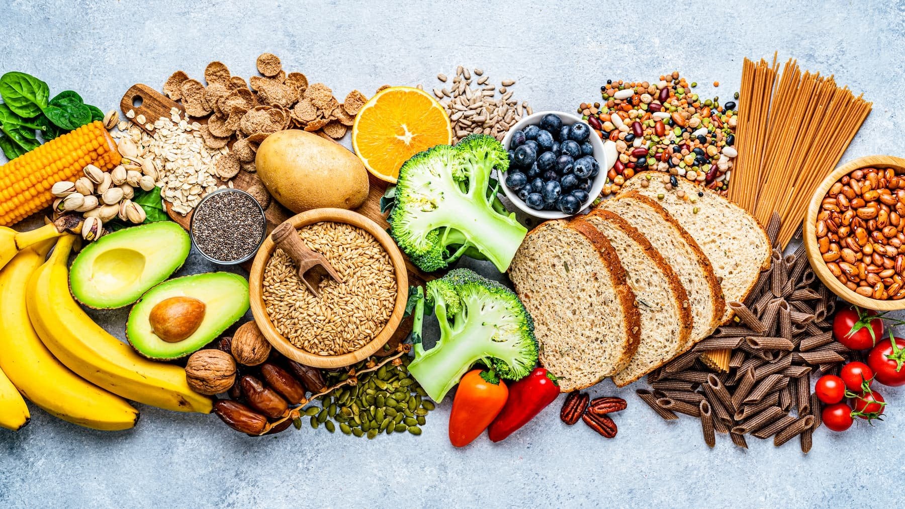 Gesunde Lebensmittel mit Vollkornprodukten, Obst, Gemüse, Hülsenfrüchten und Nüssen