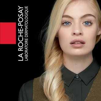 La Roche-Posay Logo und dezent geschminkte Frau mit langem, blondem Haar und blauen Augen vor schwarzem Hintergrund.