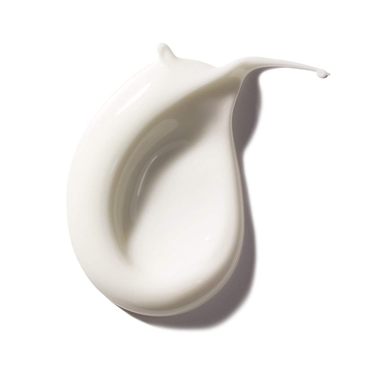 Texture crémeuse d'une lotion blanche sur fond blanc.