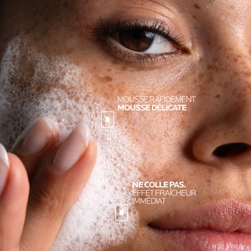 Une jeune femme aux taches de rousseur applique sur sa joue le gel nettoyant Effaclar Supramolecular, qui mousse rapidement, pour une sensation de fraîcheur dès l'application.