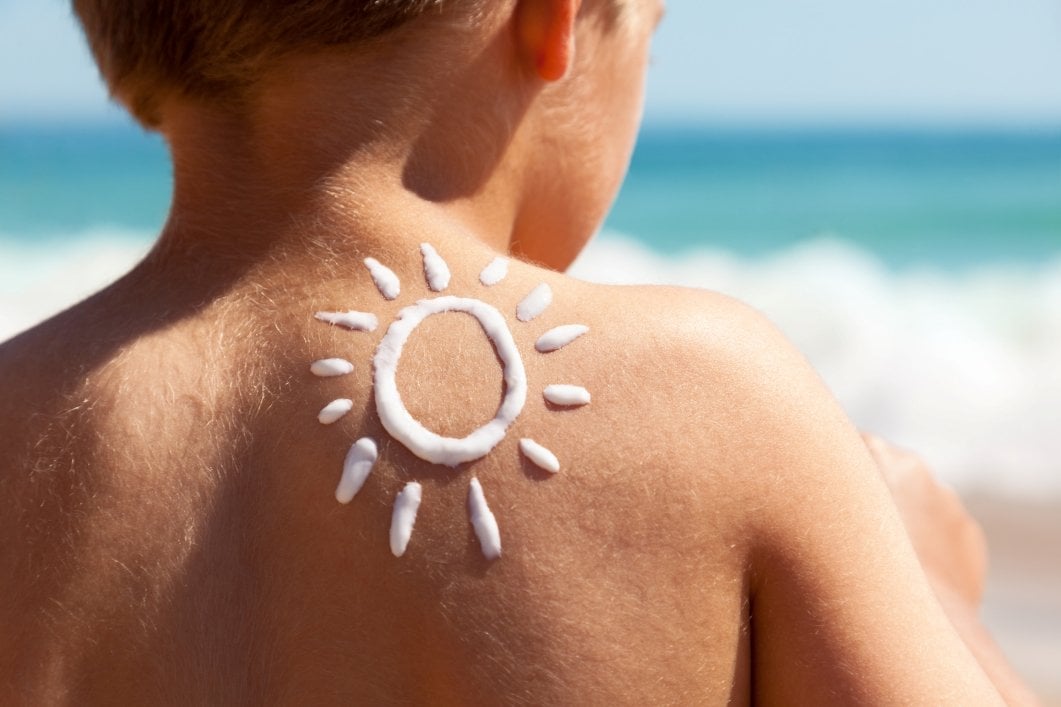 Sonnencreme in Form von einer Sonne auf der Schulter einer Person
